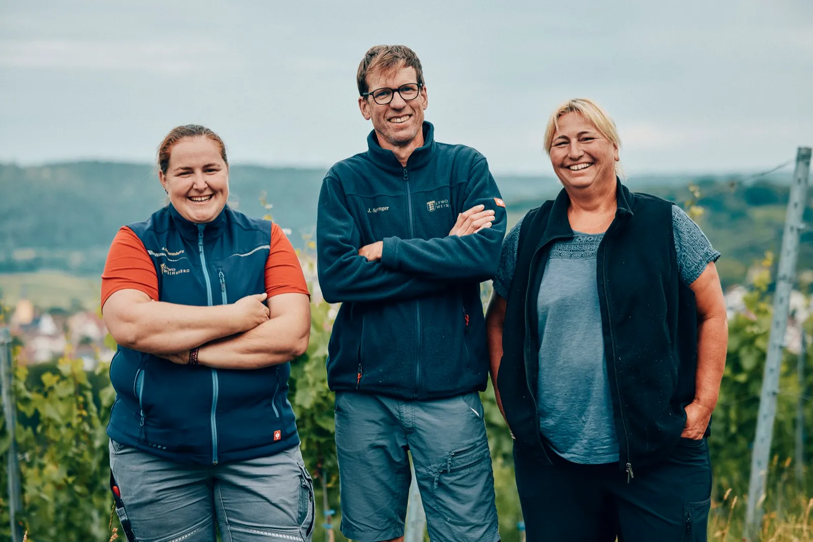 Team des Staatsweinguts über den Weinbergen